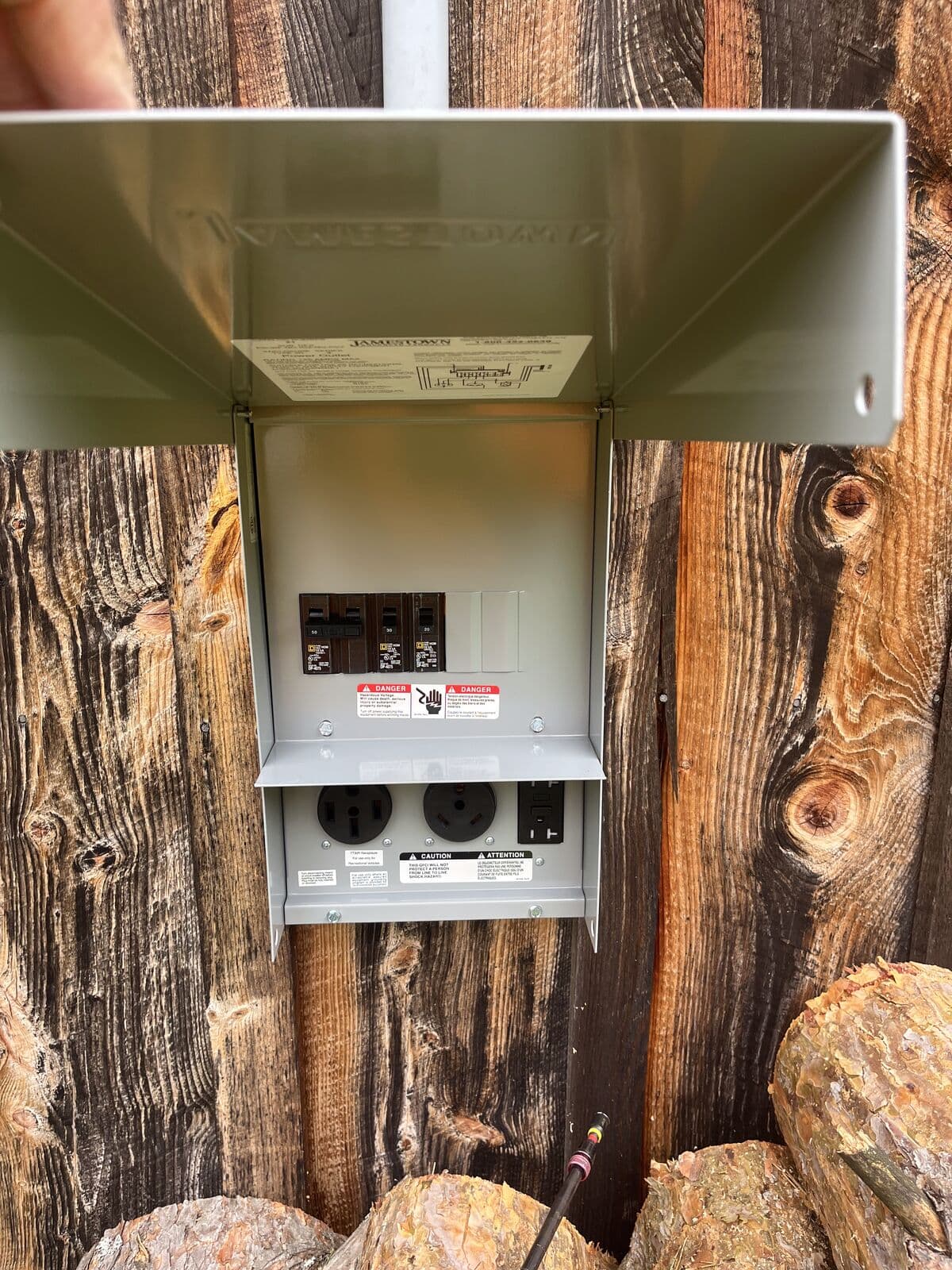 RV power pedestal mounted on a rustic wood post